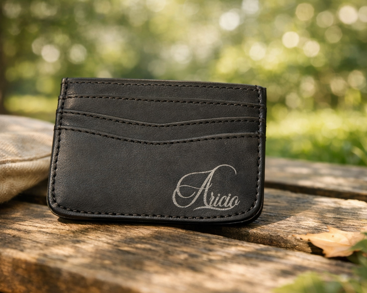 Aricio laser engraved leather C card holder photographed in a park